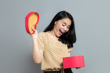 Young woman with surprised expression when opening gift box