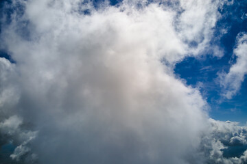 Aerial view from airplane window at high altitude of earth covered with puffy cumulus clouds...