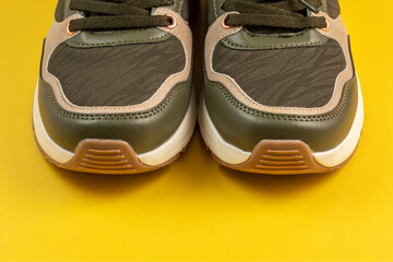 Sports shoes on yellow background. Close up.