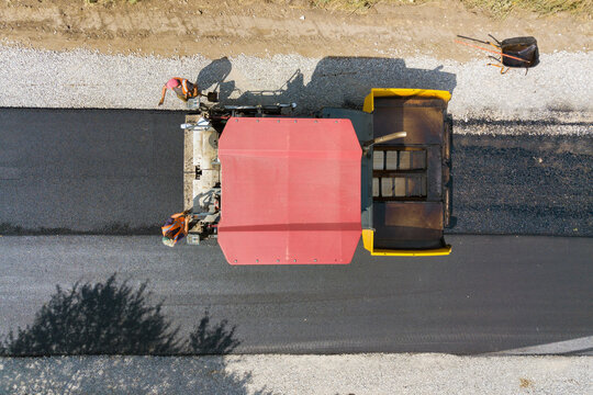 Aerial view of new road construction with asphalt laying machinery at work