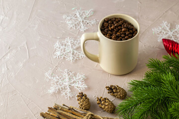 a mug with coffee beans fir twigs a bundle of brushwood pine cones Christmas decorations and snowflakes