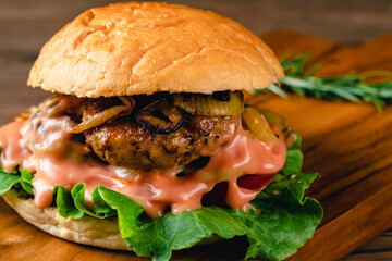 Fresh tasty chicken burger on wood table. Sandwich with chicken burger, tomatoes, pickled cucumber and fried egg. Fresh tasty chicken burger on wooden table.