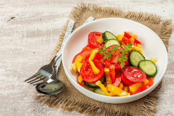 Seasonal fresh vegetable salad with ripe tomatoes, cucumbers, bell peppers