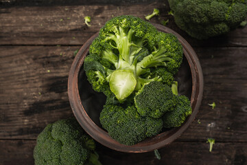 Green fresh broccoli on old wooden background. Ripe vegetables for diet and healthy eating