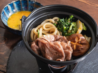 すき焼き料理。牛肉とうどんが入った鍋。