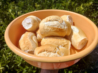 Basket full of bread in the green garden background, French bread, very popular in Brazilian cuisine 