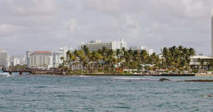 Warm day in El Boqueron Bay, San Juan, Puerto Rico. View across bay to buildings in Condando Beach. Zoom out.