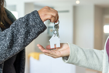 Close up of Woman Real Estate Agent handing the keys of the new home to her client. Sale of property. High quality photo