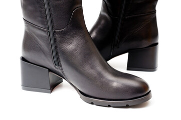 Black leather women’s boots fastened with a zipper. Background for shoes.