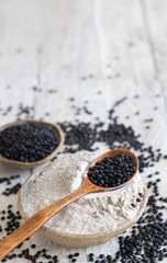 Bowls with  black lentils flour and beans on white wooden table close up