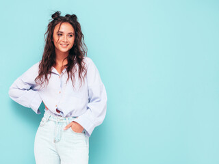 Young beautiful smiling female in trendy summer clothes. Sexy carefree woman posing near blue wall in studio. Positive brunette model having fun and going crazy. Cheerful and happy