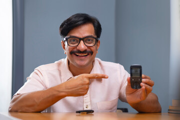Man in happy mood while blood sugar level is showing normal on Glucometer
