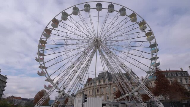 Traditional Ferris wheel spinning slowly. Ride on carousel represents entertainment