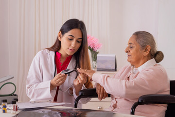 Lady doctor checking blood sugar of a senior woman