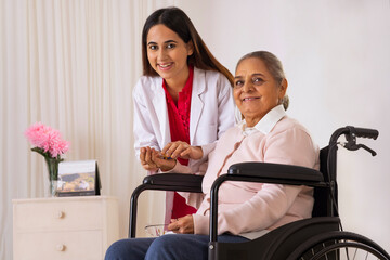 Nurse giving medicine to an old woman sitting on wheel chair