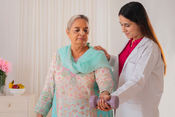 Senior woman exercising with the help of nurse