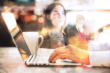 Side view of businessman hands using laptop with attractive businesswoman, coffee cup and abstract staircase filtered on blurry bokeh background. 