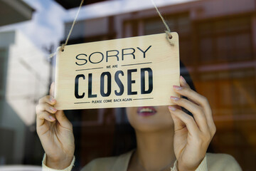 a woman turning closed sign board at a cafe or restaurant door