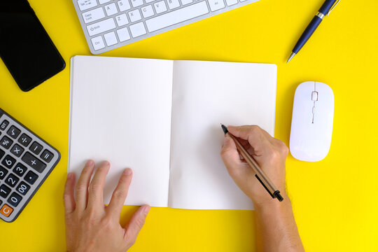 Hands Of A Man Working On A Modern Laptop Banking And Finance Topics On A Yellow Office Desktop.