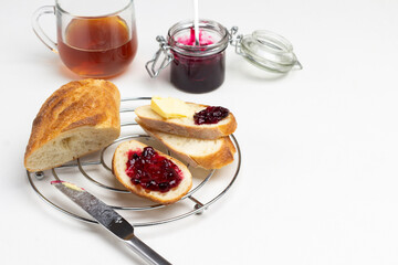 Knife, Loaf slices with butter and jam on metal stand.