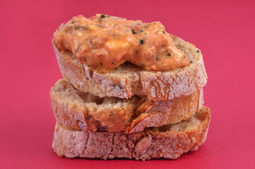 Tartines de pain empilées avec du ktipiti en gros plan sur fond rouge