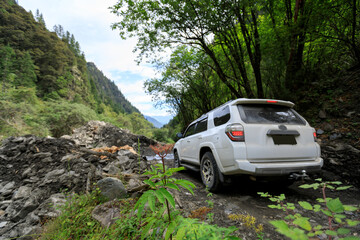 Driving off road car in the high altitude mountain forest