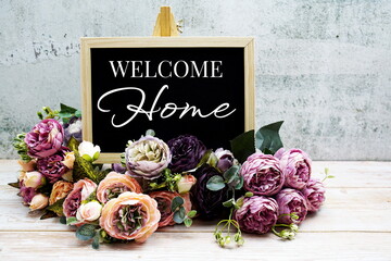 Welcome Home typography text with Flower bouquet on wooden background