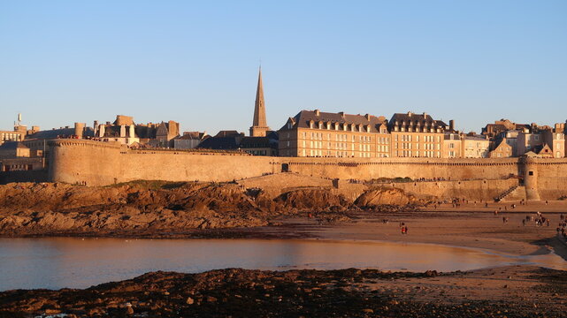 Panorama sur les remparts de la vieille ville de Saint-Malo en Bretagne, et le clocher de la cath&eacute;drale Saint-Vincent, depuis l&rsquo;&icirc;le du Grand B&eacute;, au soleil couchant (France)