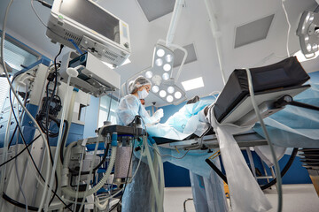 surgeon keeping track of vital functions of the body during cardiac surgery. Surgeon looking at medical monitor during surgery. Doctor checking monitor for patient health status.