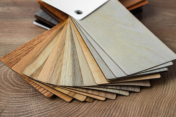 Fototapeta na wymiar Sample of wood laminated chipboard for furniture design on wooden background with copy space. Color guide displaying a range of hues for use in interior design and decoration, for designers