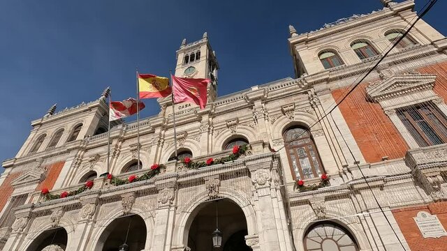 Banderas ondeando al viento en el ayuntamiento de Valladolid con decoraci&oacute;n navide&ntilde;a, Espa&ntilde;a