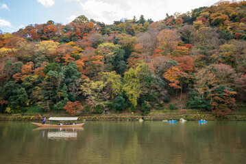Fototapeta na wymiar Traditional boat with autumn leaves in Kakegawa (river), Kyoto Arashiyama