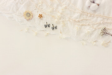 Background of white delicate lace fabric, dry flowers and pearls