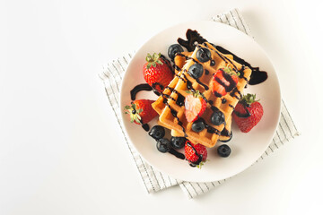 Fresh homemade food of berry Belgian waffles with honey, chocolate, strawberry, blueberry, maple...