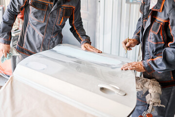 Repairing car body, Application putty close up. The mechanic repair the car. Work after the...