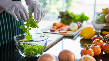 Clean fresh organic vegetable put into glass bowl by chef hands to prepare natural ingredient for cooking healthy vegan food