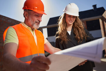 Ambitious builders studying the paper plans of the construction