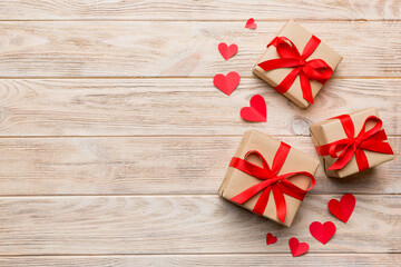Valentine day composition: red gift box with bow and heart. Christmas present. View from above. Space for text. Holday greeting card