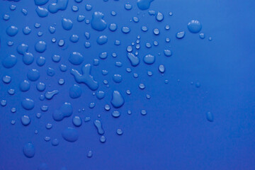 splashes of water drops on a blue background. A round drop of water. Drops, splashes, splashes, abstract figures from the water.