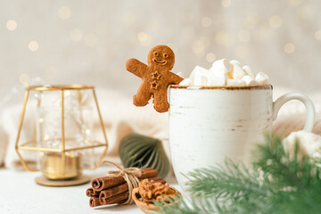 Gingerbread man cookie in cup of hot cocoa or coffee with marshmallow, fir tree and warm cozy...