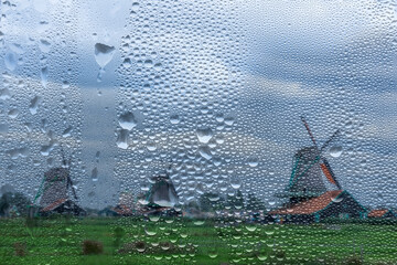 View Through a Rainy Window to Old Windmills in the Netherlands