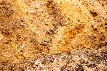 Textural sand, with  relief surface, multi-colored layers and different in size of granules, in outdoor sand career, after mining ore and sand for construction.