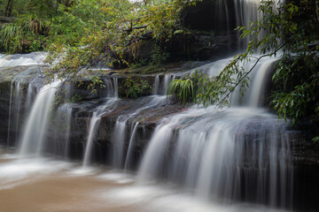 Obraz premium Water flowing between rock formation in the forest.