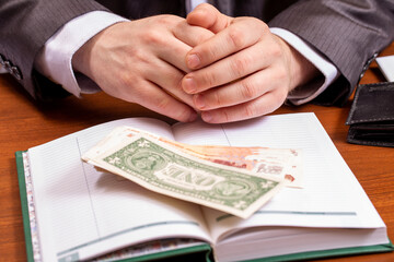Obraz premium Businessman hands, notebook and dollar on table