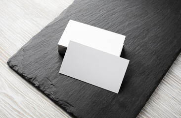 Photo of blank business cards stack on stone board. Template for branding identity.