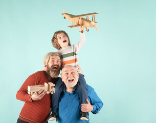Three different generations ages grandfather father and child son playing with toy plane in studio. Journey travel trip concept. Isolated background. Family adventure, innovation inspiration.