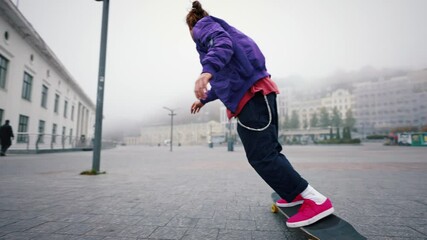 Full length rear view of young man skateboarding while hanging out at the city square outdoors. Find your freedom - Powered by Adobe