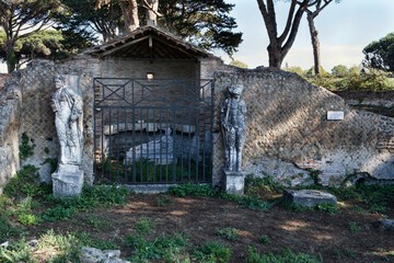 The Shrine of Attis or Attideum with its graven statues surrounded by ancient ruins, a beautiful cultural travel in the Roman age at archeological excavations of Ostia Antica in Rome, Italy