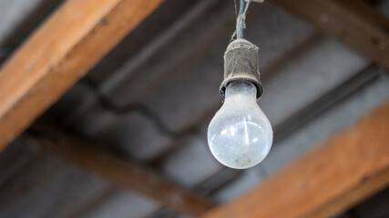 An old vintage Soviet light bulb in the garage. Light bulb in the dust