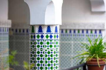 Detail of the interior traditional Moroccan Riad or Riyad with pillar covered by tilles, Morocco